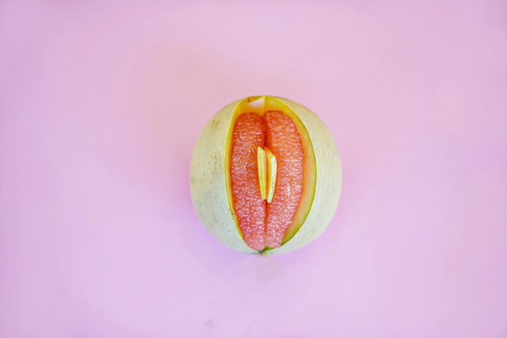Artistic image of a grapefruit with a pink backdrop. Abstract and conceptual.