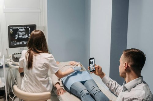 pexels-photo-7108422-7108422 A woman receives an ultrasound as her partner watches and records the session on a smartphone.